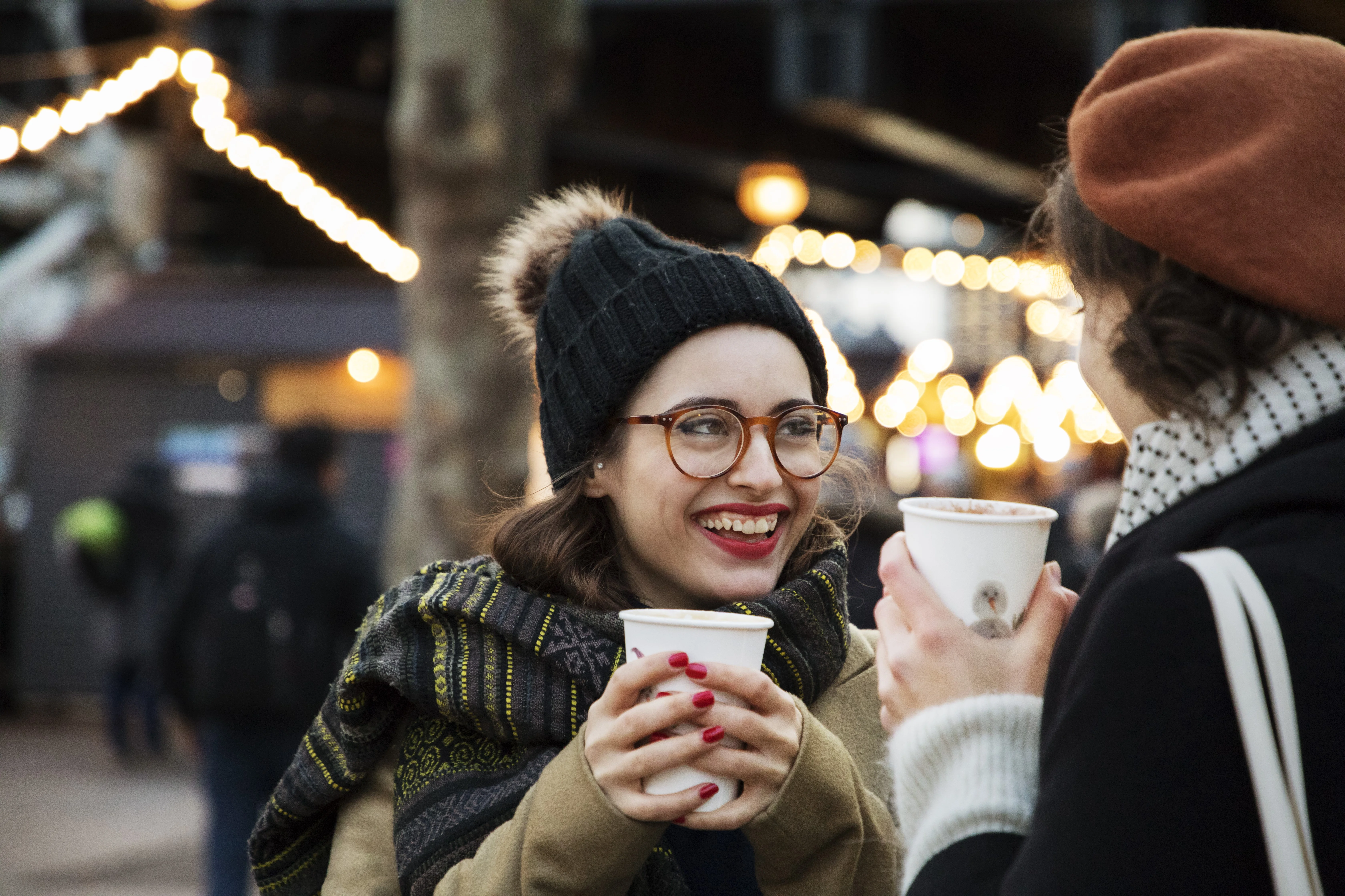 uma pessoa segurando um copo e um telefone celular