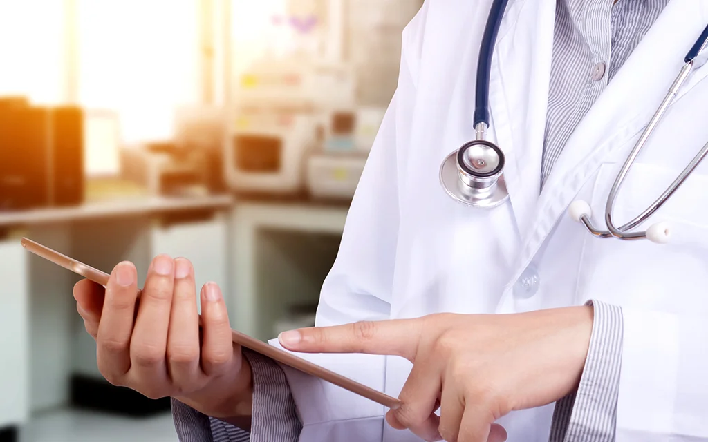 a doctor holding a stethoscope and a tablet